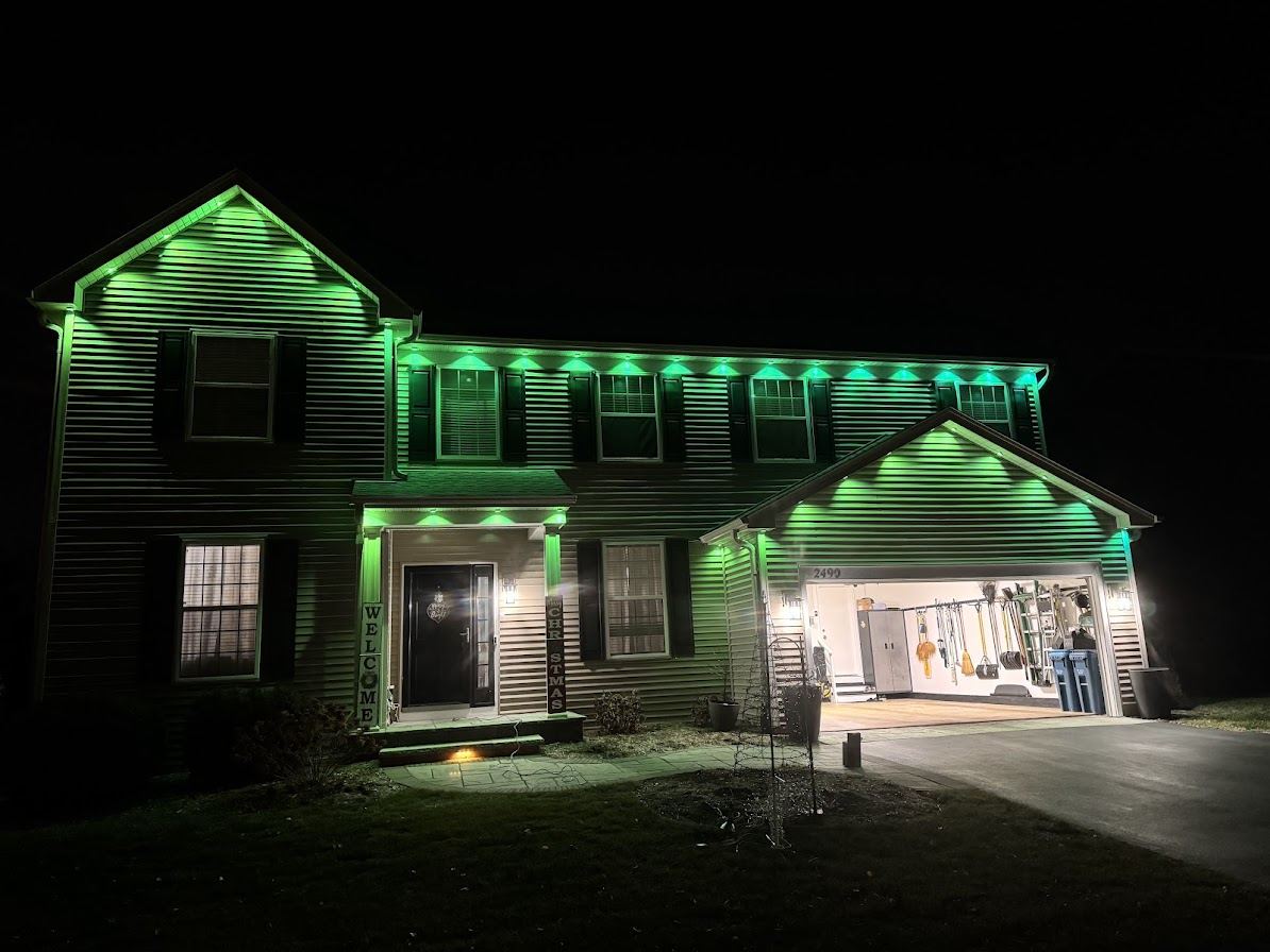 House at night with green permanent roofline lighting