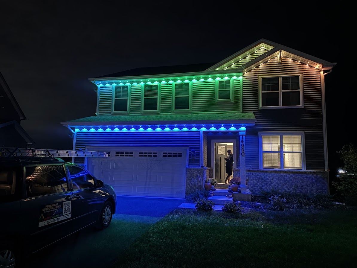 House at night with green and blue permanent roofline lighting