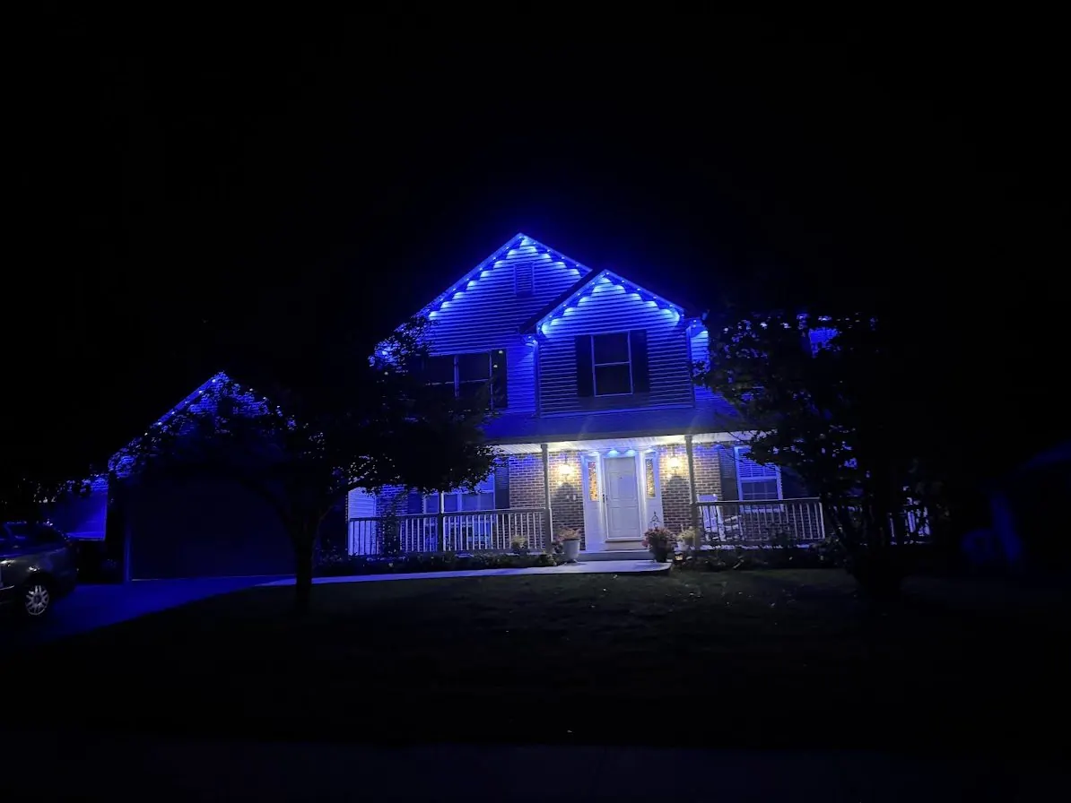 House at night with blue permanent roofline lighting