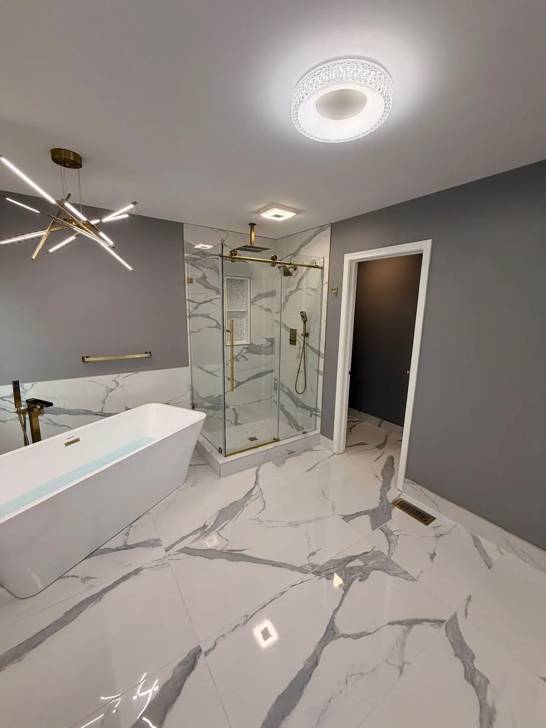Marble-look tiled tub surround with gold-tone fixtures